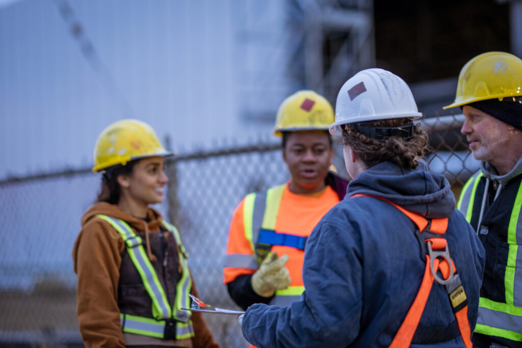 Bauarbeiter besprechen nächste Aufgaben auf der Baustelle während einer kurzen Pause